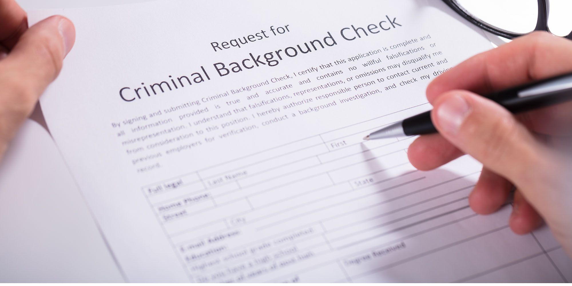 Person Hand Filling Criminal Background Check Application Form